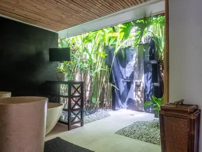 a bathroom with a sliding glass door to a garden at Ocean Star 1 in Seminyak