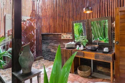 a room with a table and a mirror and plants at Ocean Star Villa Four Bedrooms Seminyak in Seminyak