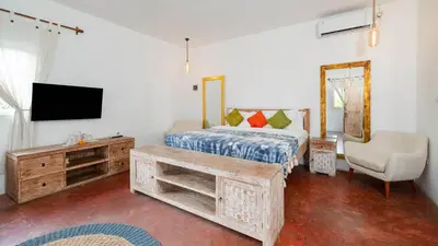 a bedroom with a bed and a tv and a chair at Ocean Star 2 in Seminyak