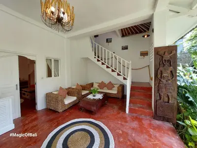 a living room with a staircase and a couch at Ocean Star 3 in Seminyak