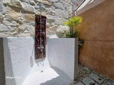 a window on a stone wall with a plant at Ocean Star 3 in Seminyak
