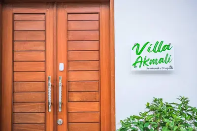 a wooden door with a sign on the side of a building at Villa Akmali Seminyak Drupadi 2 Bedrooms w/Pool 5mins to Beach in Seminyak
