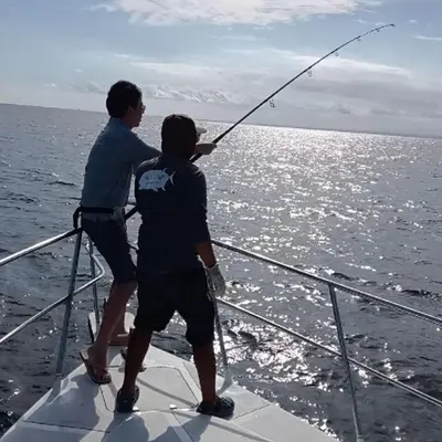 two men on a boat fishing in the ocean at PIMA Homestay in Pesanggaran