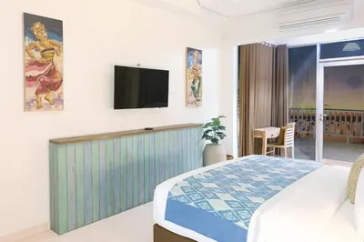 a bedroom with a bed and a tv on the wall at PIMA Homestay in Pesanggaran