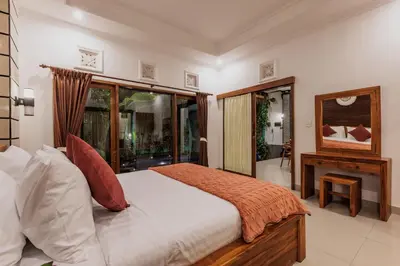 a bedroom with a large bed and a fireplace at Padma Villa I in Legian