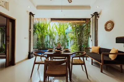 a dining room with a table and chairs and a couch at Padma Villa I in Legian