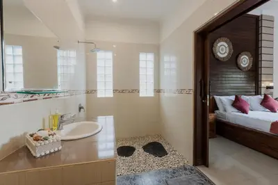 a bathroom with a sink and a bed at Padma Villa I in Legian