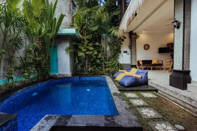 a swimming pool in the middle of a room with plants at Padma Villa I in Legian