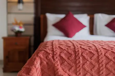 a bed with a red comforter and red pillows at Padma Villa I in Legian