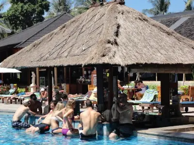 a group of people sitting in a swimming pool at Private Apartment inside Beach Resort Jayakarta in Seminyak