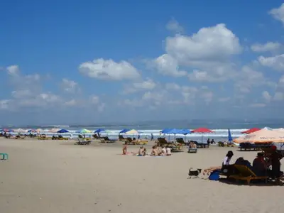 a group of people on a beach with umbrellas at Private Apartment inside Beach Resort Jayakarta in Seminyak