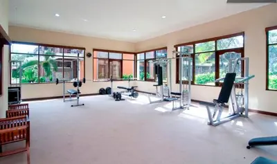 a large room with a gym with several treadying machines at Private Apartment inside Beach Resort Jayakarta in Seminyak