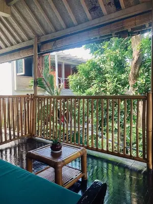 a patio with a table and a wooden fence at Goestlie Berawa in Canggu