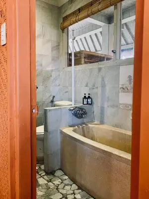 a bathroom with a large tub and a toilet at Goestlie Berawa in Canggu
