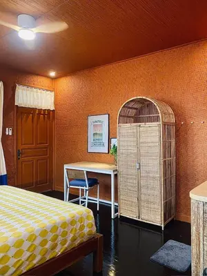 a room with a bed and a table and a bird cage at Goestlie Berawa in Canggu