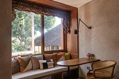 a living room with a couch and a table and a window at Goestlie Berawa in Canggu