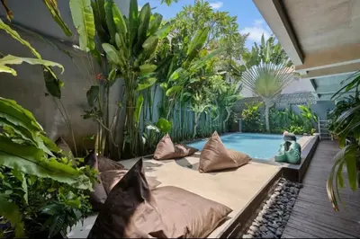 a garden with a pool and some plants at Modern Apartment with Shared Pool - By the Beach in Seminyak
