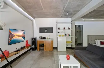 a living room with a couch and a table at Modern Apartment with Shared Pool - By the Beach in Seminyak