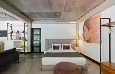 a bedroom with a large bed and a couch at Modern Apartment with Shared Pool - By the Beach in Seminyak
