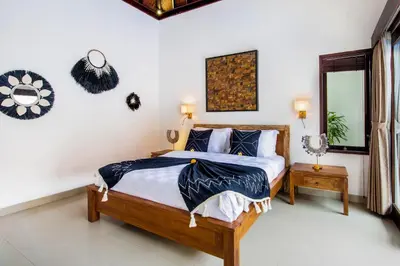a bedroom with a bed and a mirror at Villa Joyosa in Seminyak