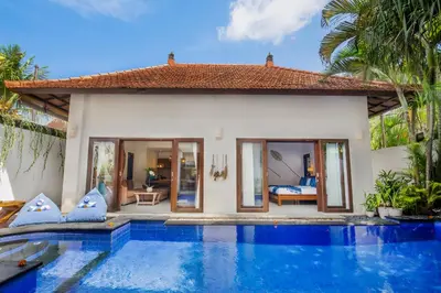 a villa with a swimming pool in front of a villa at Villa Joyosa in Seminyak