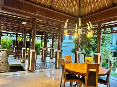 a dining room with a wooden table and chairs at Mai Villa in Jimbaran