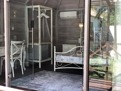 a room with a bed and a table and chairs at Bali WOW! Bungalows, Nusa Dua Benoa in Nusa Dua