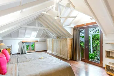 a bedroom with a large bed and a large window at La Villa Oberoi (2 BR) in Seminyak
