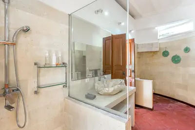 a bathroom with a shower and a glass wall at La Villa Oberoi (2 BR) in Seminyak