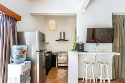 a kitchen with a refrigerator and a counter with stools at La Villa Oberoi (2 BR) in Seminyak