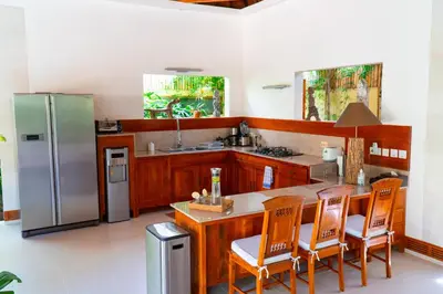 a kitchen with a refrigerator and a table and chairs at Villa Dayak in Seminyak