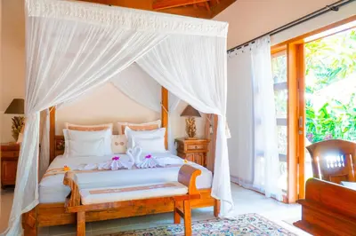 a bedroom with a bed with a canopy at Villa Dayak in Seminyak