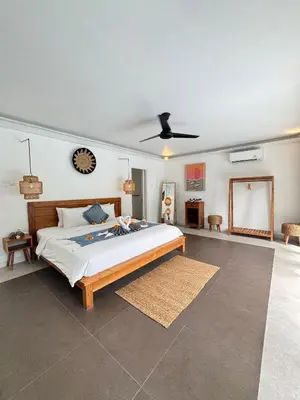 a bedroom with a bed and a clock on the wall at Lalita Villas Seminyak in Seminyak