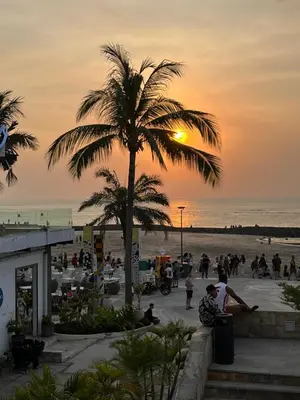 a palm tree on the beach at sunset at 5 Bedroom Holiday Villa - Kuta Regency B8 in Kuta