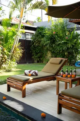 a bed sitting on a deck next to a pool at Villa bella wilson in Seminyak