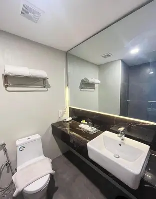 a bathroom with a sink and a toilet and a mirror at Horison Le Aman Bali in Jimbaran
