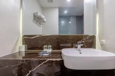 a bathroom with a white sink and a mirror at Horison Le Aman Bali in Jimbaran