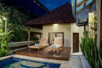 a patio with two chairs and a swimming pool at Villa Tunjung Batubelig Canggu in Canggu