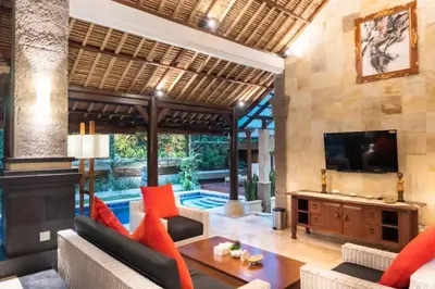 a living room with a tv and a couch and a table at Villa Tunjung Batubelig Canggu in Canggu
