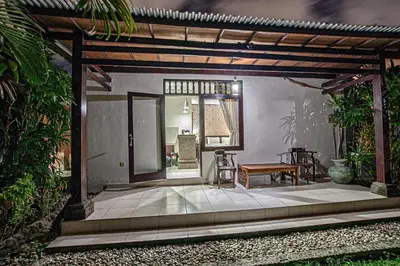 a house with a patio with a table and a bench at Panorama Cottages I in Legian