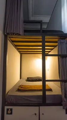 a top bunk bed with a yellow blanket on it at Sunshot Hostel in Legian