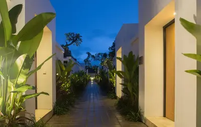 a long pathway between two buildings with plants at The Kon's Villa Bali Seminyak in Seminyak