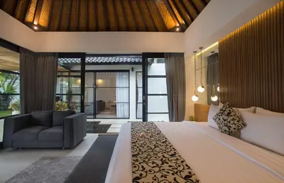 a bedroom with a large bed and a couch at The Kon's Villa Bali Seminyak in Seminyak