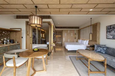 a hotel room with a bed and a table and chairs at AYANA Segara Bali in Jimbaran
