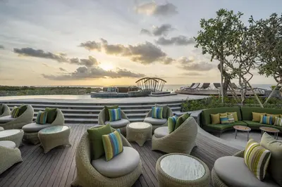 a patio with couches and chairs on a deck at AYANA Segara Bali in Jimbaran