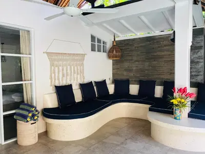 a bench on a patio with a ceiling at Villa Elleo in Seminyak
