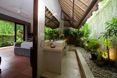 a bathroom with a sink in a room with plants at Villa Elleo in Seminyak
