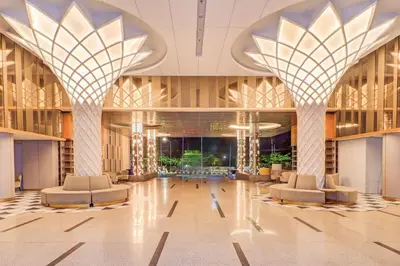 a lobby with couches and chairs in a building at Sunday Hotel Arshika Sunset Road in Kuta