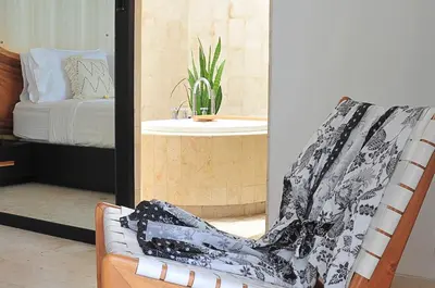 a room with a chair and a sink and a bed at Villa Zensa @ The Residence Seminyak in Seminyak