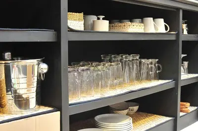 a shelf filled with glasses and plates and bowls at Villa Zensa @ The Residence Seminyak in Seminyak